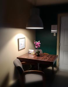 einen Esstisch mit einer Blumenvase darauf in der Unterkunft Motel Alexandrin in Saint-Georges