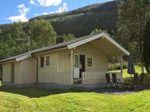 a small house with a table and chairs in a yard at 4 person holiday home in Utvik-By Traum in Reed +11 photos
