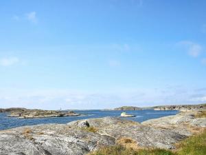 un gran grupo de rocas en el agua en 6 person holiday home in H LLEVIKSSTRAND en Hälleviksstrand