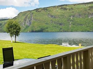 vistas a un lago con un banco y un árbol en Two-Bedroom Holiday home in Utvik 2, en Reed