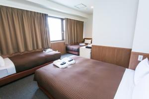 東京にあるオークホテル江戸のベッド2台とデスクが備わるホテルルームです。