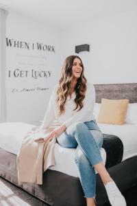 a woman sitting on top of a bed at The Lucky Hotel in Newcastle