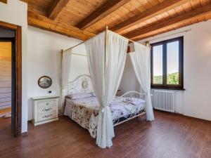 1 dormitorio con cama con dosel y techo de madera en Belvilla by OYO Valdalto, en Piandimeleto