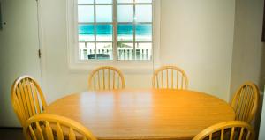 a wooden table with chairs and a view of the ocean at The Beach Cottages in San Diego