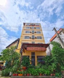 a tall yellow building with plants in front of it at Khách sạn Tam Sơn in Ha Giang
