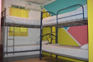 Habitación con 3 literas y una pared colorida. en Casa Michael, en Guayaquil