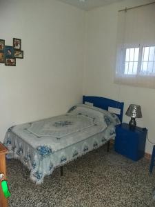 ein Schlafzimmer mit einem Bett und einer Lampe auf einem Tisch in der Unterkunft PENSION LA FUENTE in Abrucena