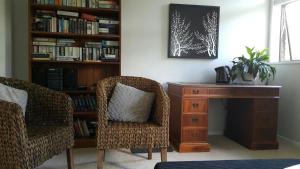 a desk and two chairs in a room with a book shelf at Kerry Lodge Bed & Breakfast in Napier
