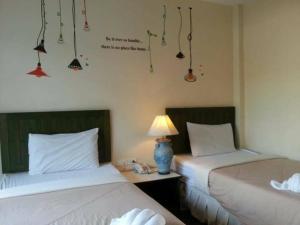 two beds sitting next to each other in a room at Baan Suksiri Hotel in Hua Hin