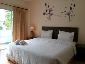 Postel nebo postele na pokoji v ubytování Baan Suksiri Hotel