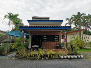 a small building with a blue roof and plants at Nestvilla Khok-kloi Phang-nga in Ban Nai