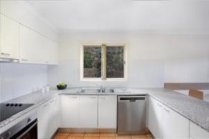 a kitchen with a stove top oven and a window at BreakFree Aanuka Beach Resort in Coffs Harbour