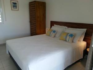sypialnia z dużym białym łóżkiem z poduszkami w obiekcie SNP- PALMS w mieście Papetoai