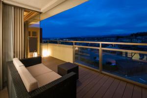 a balcony with a couch and a view of a city at Yunokuni Tensyo in Kaga