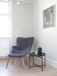 uma cadeira azul e uma mesa num quarto em ApartmentInCopenhagen Apartment 1143 em Copenhague