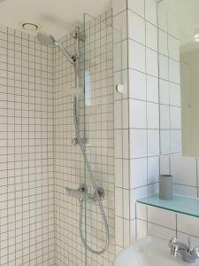 uma casa de banho com um chuveiro e um lavatório. em ApartmentInCopenhagen Apartment 1143 em Copenhague