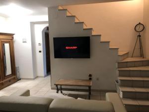 - un salon avec un canapé et une télévision murale dans l'établissement Maison Montefino, à Montefino
