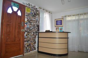 um quarto com uma secretária, uma porta e uma parede com fotografias em Casa Michael em Guayaquil