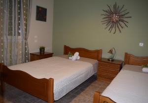 ein Schlafzimmer mit 2 Betten und einer Uhr an der Wand in der Unterkunft Garden's Villa in Leptokaryá