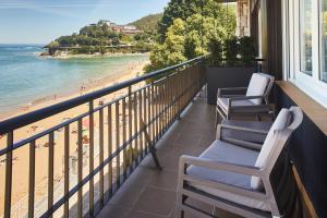 
a balcony overlooking a beach with a view of the ocean at Hotel Silken Palacio Uribarren in Lekeitio
