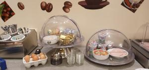 eine Küchentheke mit Eiern und Lebensmitteln in einer Glasglocke in der Unterkunft Schleswig Holstein Hotel in Elmshorn