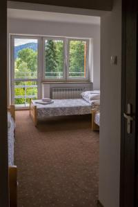 a bedroom with two beds in front of a window at Dom Pszczelarza w Kamiannej in Łabowa