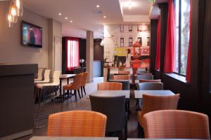 a restaurant with tables and chairs and a bar at Hotel Sixteen Paris Montrouge in Montrouge