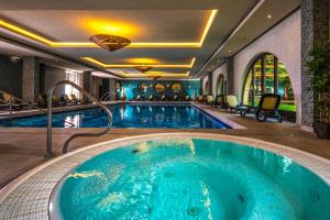 uma piscina num quarto de hotel com uma grande banheira em Budapest Airport Hotel Stáció Wellness & Konferencia em Vecsés