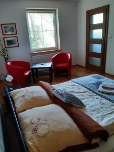 a bedroom with a bed and two chairs and a window at Kozi Lasek in Koluszki