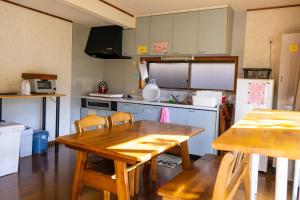 a kitchen with a wooden table and a table and chairs at 黒まめ庵 in Tamba