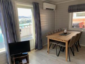 
a dining room table and chairs in front of a large window at Garsnes Brygge in Sjøvegan
