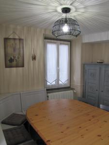 a dining room with a wooden table and a window at Maison de village dans une rue calme in Ax-les-Thermes