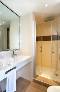 a bathroom with a sink and a shower at B&B HOTEL Montbéliard-Sochaux in Sochaux