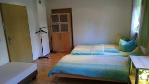 a bedroom with two twin beds and a window at Ferienwohnung Steinwald Ausläufer mit Blick auf Kösseine in Waldershof