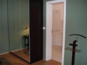 um quarto com uma porta de vidro e um espelho em Apartmány Kamenky em Teplice