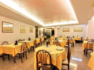 un restaurant avec des tables et des chaises et un tissu de table jaune dans l'établissement Hotel Carancini, à Salsomaggiore Terme