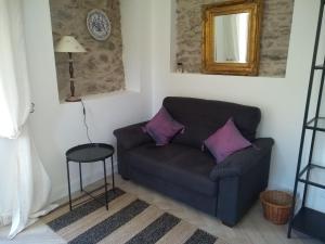 un soggiorno con divano e cuscini viola di La Petite Grange a Reynès
