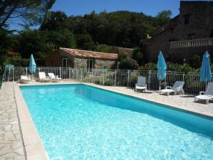 - une piscine avec des chaises longues et des parasols dans l'établissement La Petite Grange, à Reynès