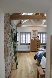 Un dormitorio con una cama y una pared de piedra. en Bryher Cottage, en Paul