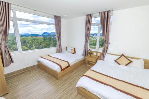 Postel nebo postele na pokoji v ubytování Lacami Dalat Hotel