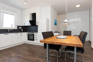 a kitchen and dining room with a wooden table and chairs at Luxury Apartment Lukas Pool & Parking Vodice in Vodice