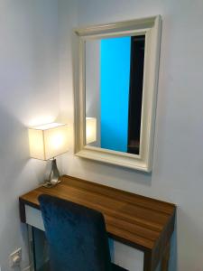 Camera dotata di scrivania con specchio e sedia. di Mansion One Suites by Little Cabin a George Town
