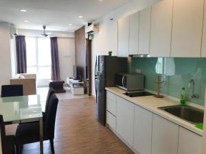 cocina con nevera negra y mesa con comedor en Mansion One Suites by Little Cabin, en George Town