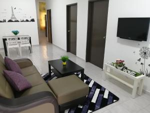 a living room with a couch and a tv at SKYHOMESTAY TELOK PANGLIMA GARANG in Teluk Panglima Garang