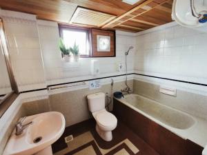 a bathroom with a tub and a toilet and a sink at My Home Apartment - Villa Dahlia Apartment in Cameron Highlands +24 photos