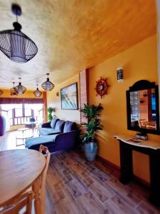 a living room with a blue couch and a tv at My Home Apartment - Villa Dahlia Apartment in Cameron Highlands
