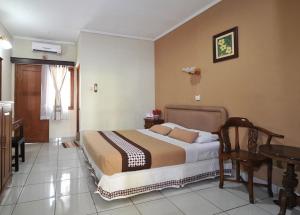 Un dormitorio con una cama y una mesa. en Hotel Mataram Malioboro en Yogyakarta