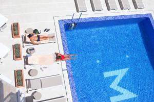 薩科馬的住宿－Hotel MiM Mallorca & Spa - Adults Only，游泳池的顶部景色,2人躺在椅子上