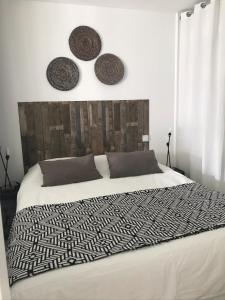 ein Schlafzimmer mit einem Bett mit zwei Hüten an der Wand in der Unterkunft Au calme du bois du Pouliguen plage et port à pied in Le Pouliguen