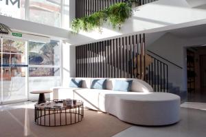 uma sala de estar com um sofá branco e uma mesa em Hotel MiM Mallorca & Spa - Adults Only em Sa Coma